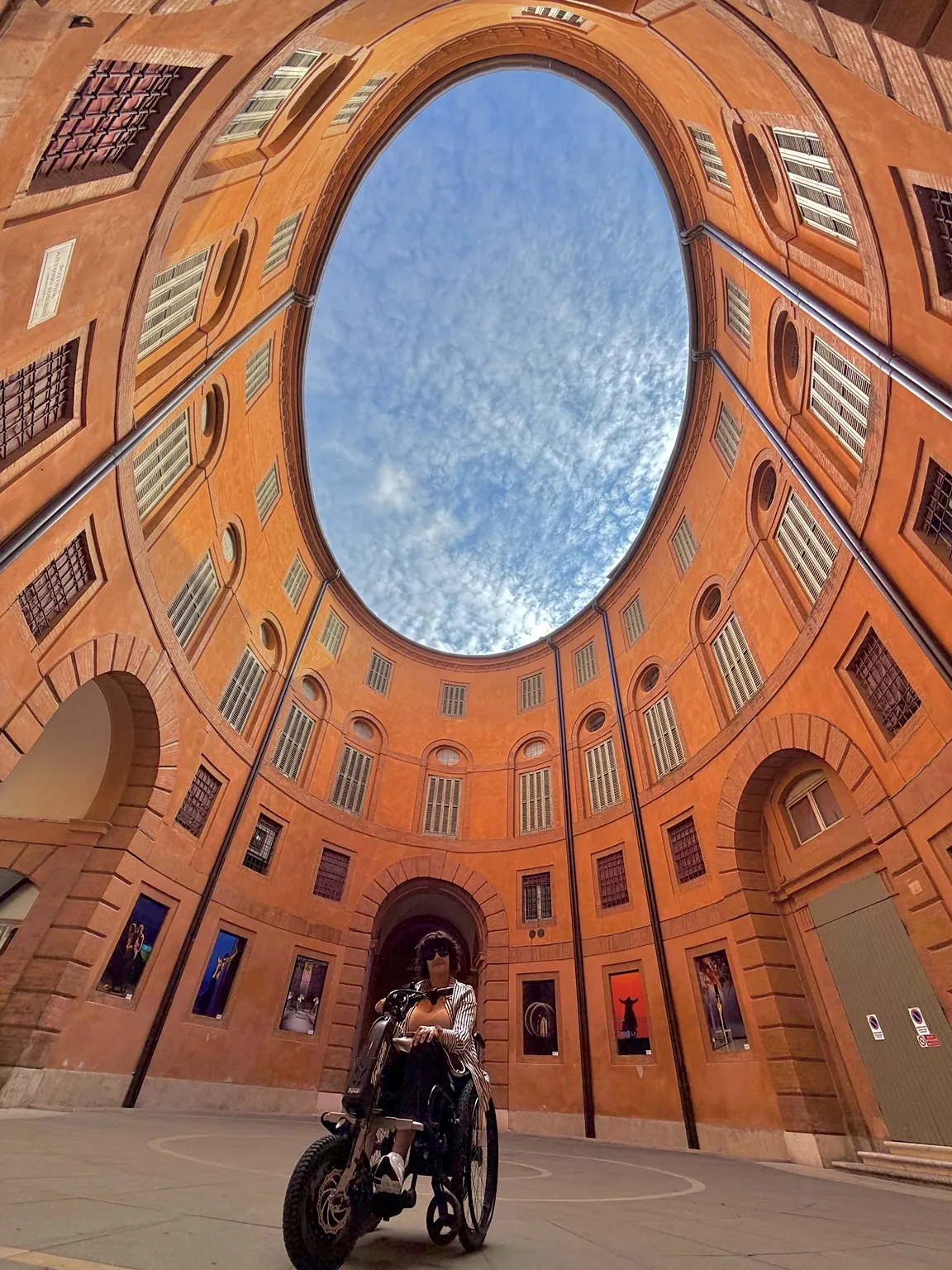 Anna sul suo Triride al centro della Rotonda Foschini, circondata dalle pareti color arancio con le finestre.
