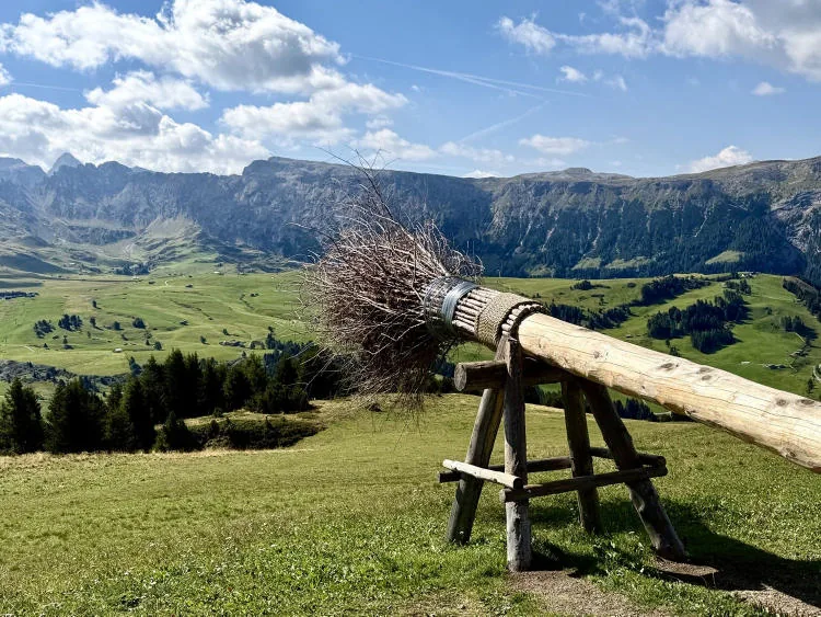 The meadows of the Bullaccia and the Alpe di Siusi plateau under a sky with a few clouds.