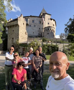 Group photo in front of Castel Presule: Anna in her wheelchair in the middle, surrounded by friends.