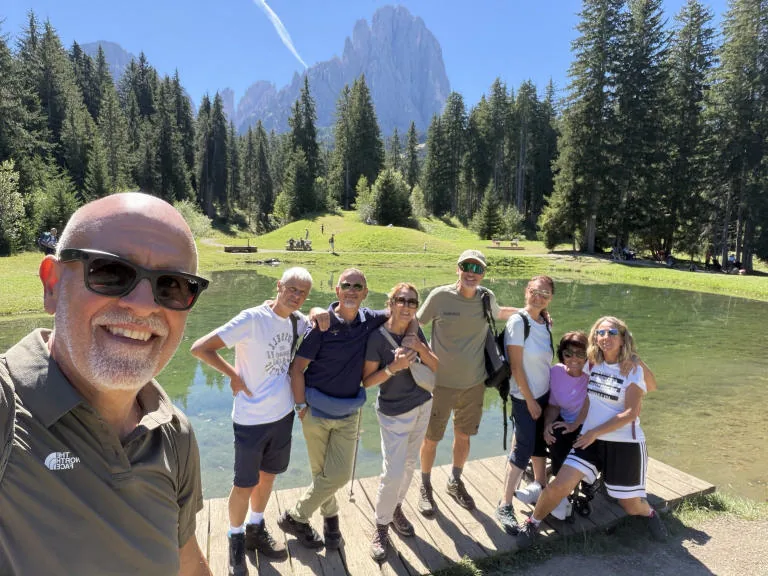 Group selfie on the wooden boardwalk by the biotope: smiling friends and Anna in her wheelchair.