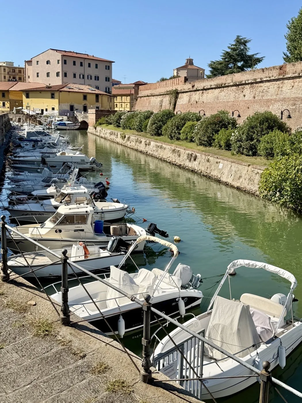 Boats moored along one of the Medici canals, with the old brick walls on the right.