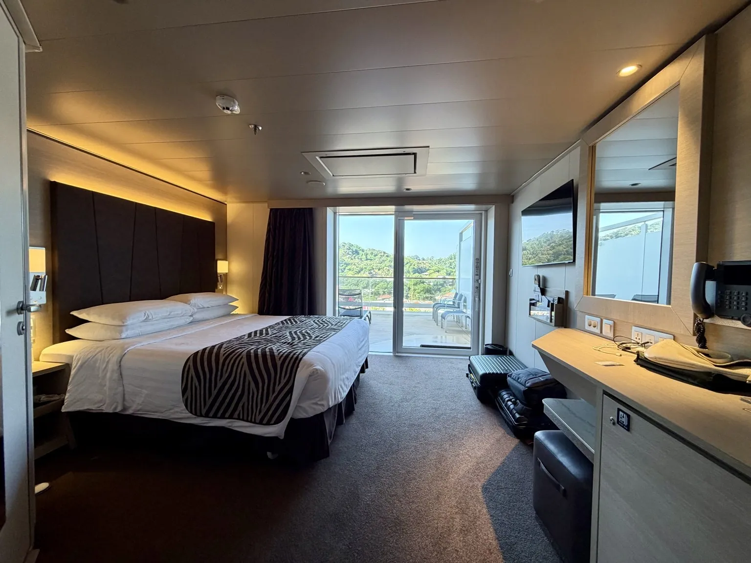 A spacious cabin with a double bed, room to move around and a large glass door onto the balcony.