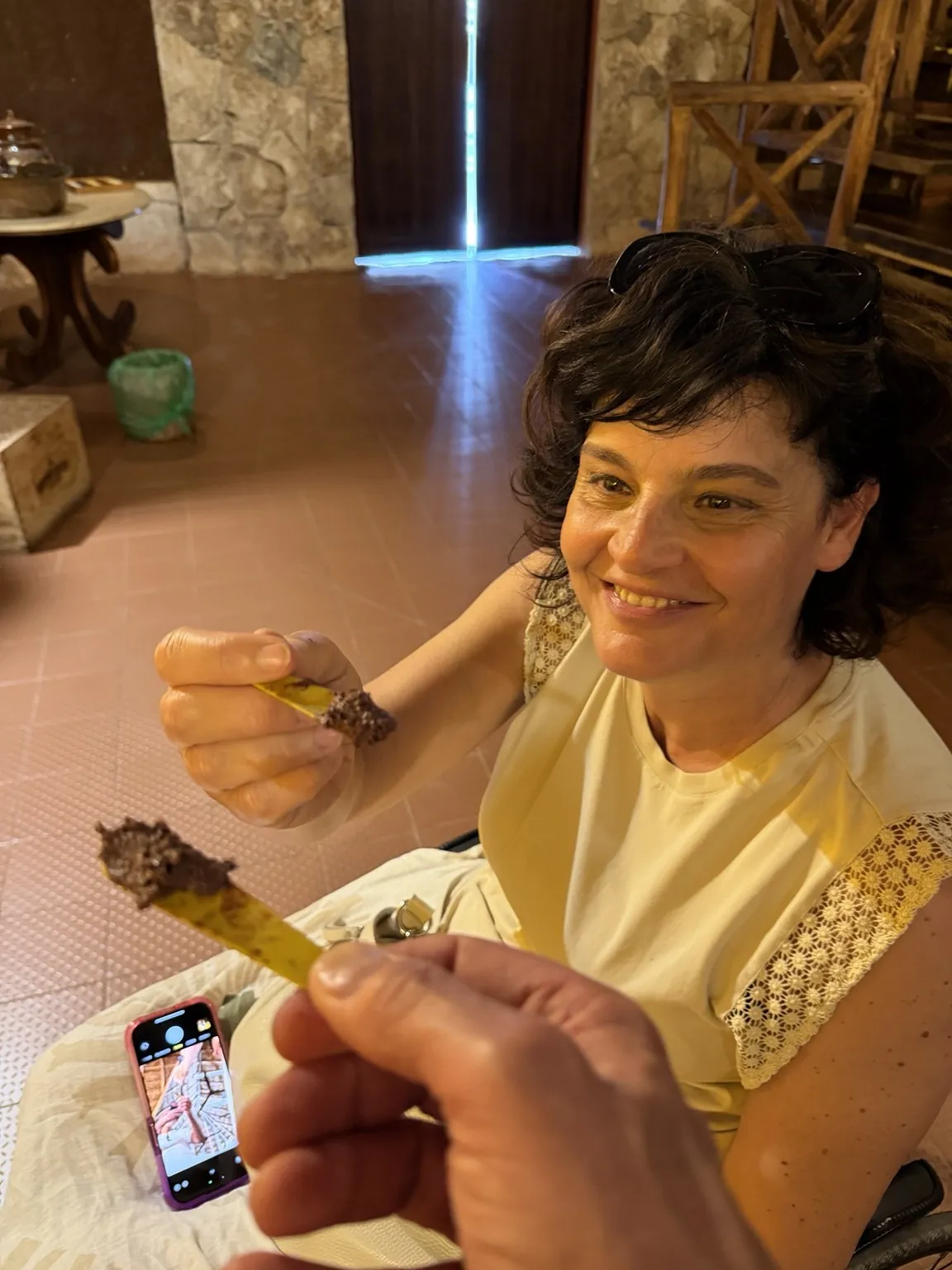 Anna smiles as she tastes the cacao from a small spoon.