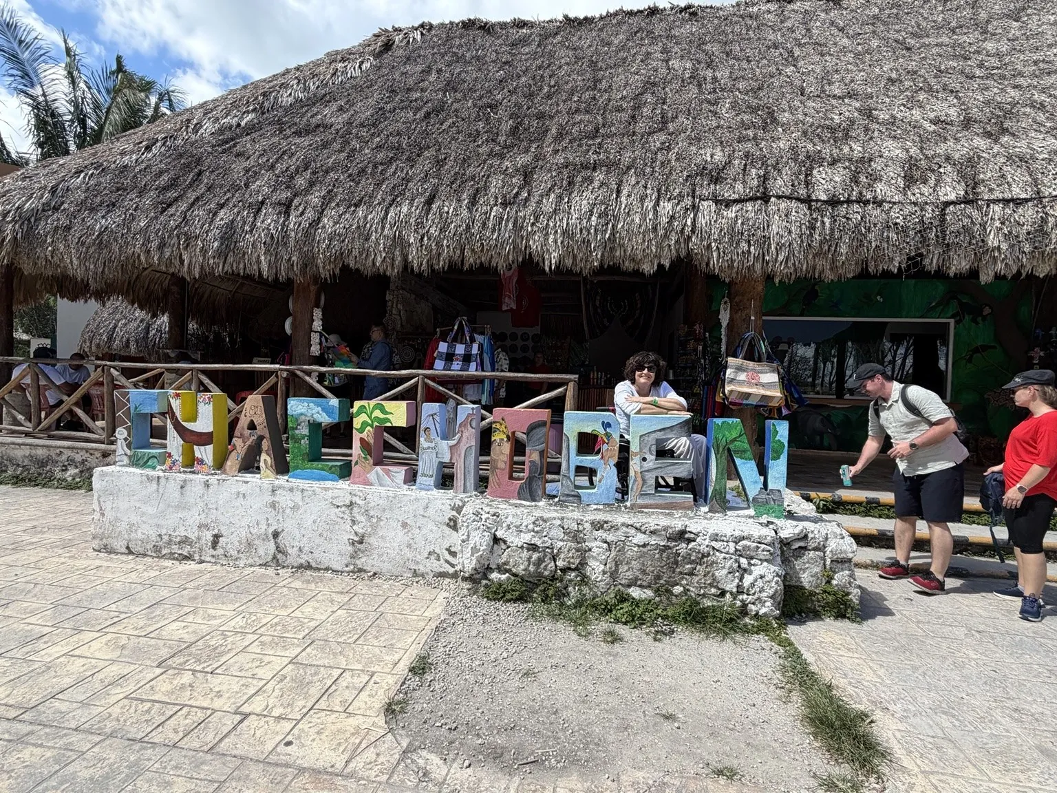 The word “Chacchoben” in big colourful letters in front of a thatched-roof building.