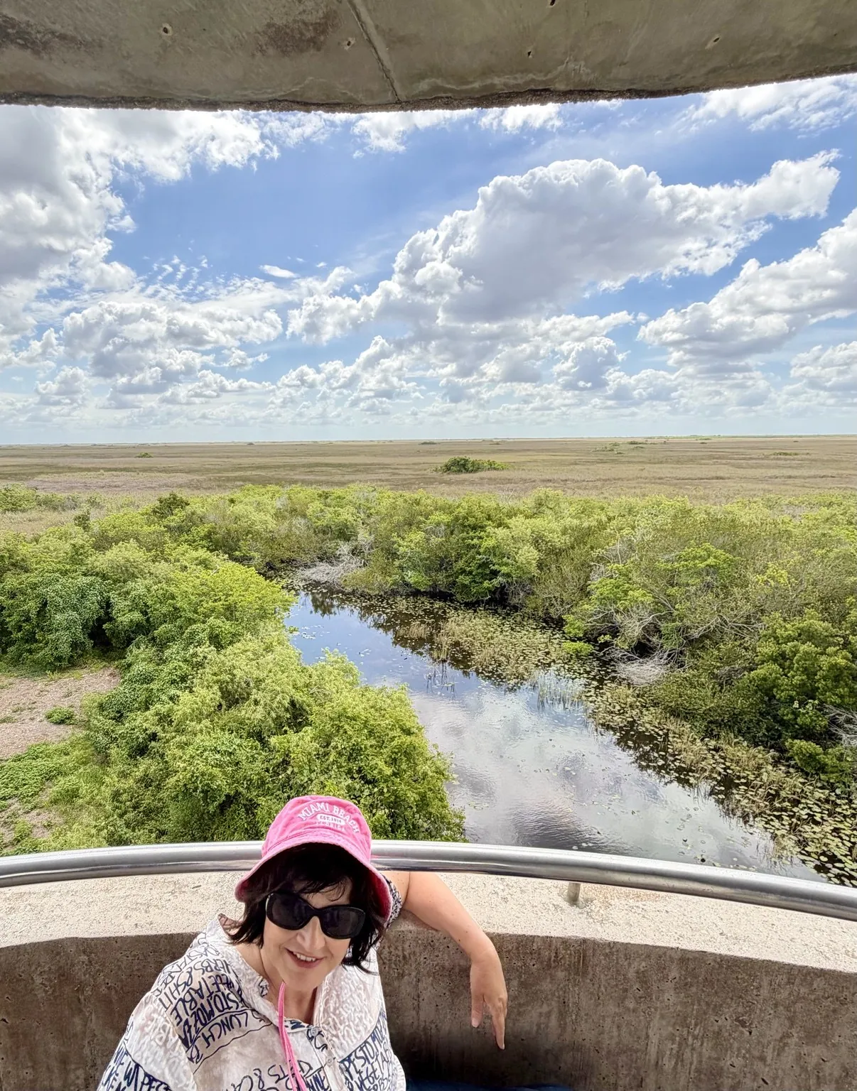 Anna at the tower’s parapet; below her, a canal, the vegetation and the prairie stretching to the horizon.