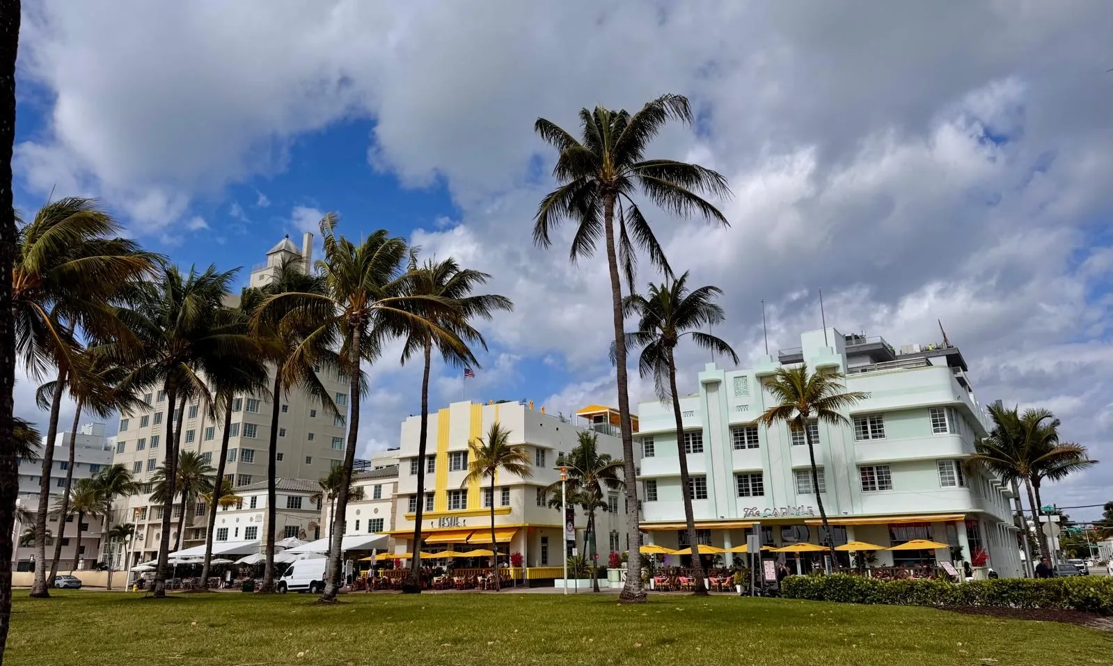 A row of palm trees in front of the pastel-coloured Art Deco hotels of Ocean Drive.