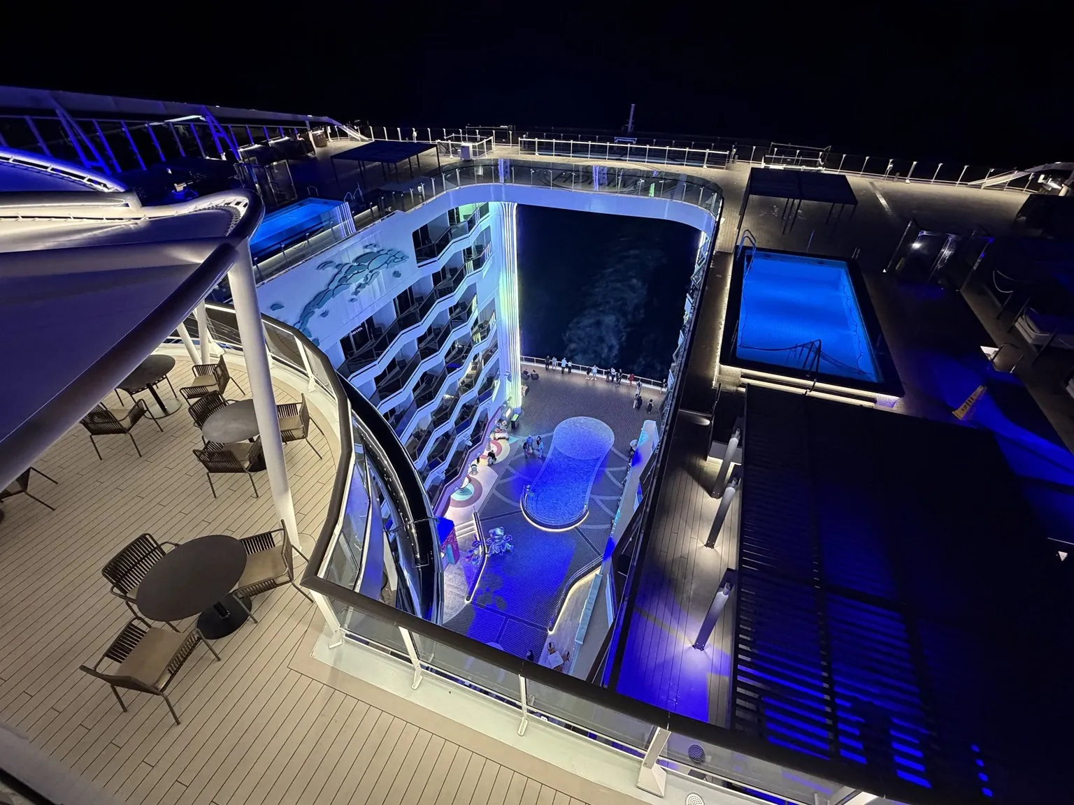 The promenade seen from a high deck at night, lit by blue lights.